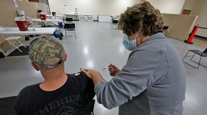Patricia Hart, a registered nurse, gives a COVID vaccine shot at the Clark County Combined Health District's vaccine center on Leffel Lane. BILL LACKEY/STAFF