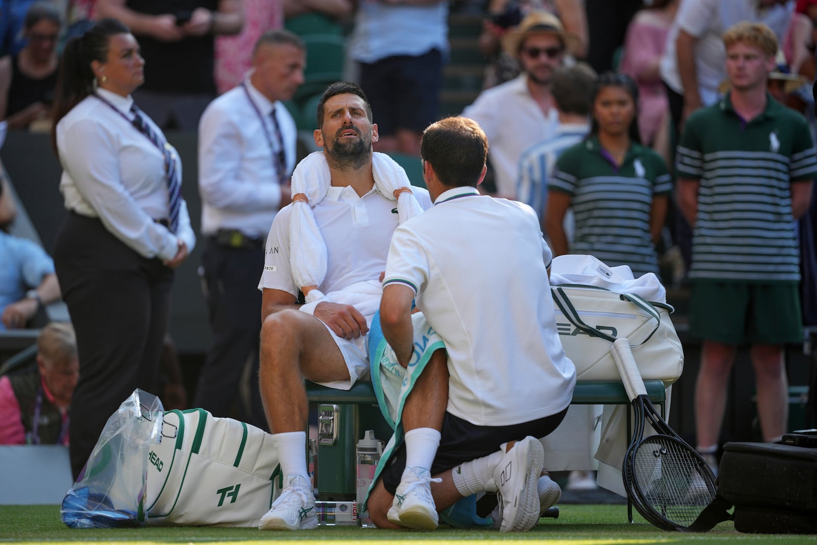 Serbia's Novak Djokovic gets treatment during a medical timeout break against Italy's Jannik Sinner in a men's singles semifinal at the Wimbledon Tennis Championships in London, Friday, July 11, 2025. (AP Photo/Kin Cheung)