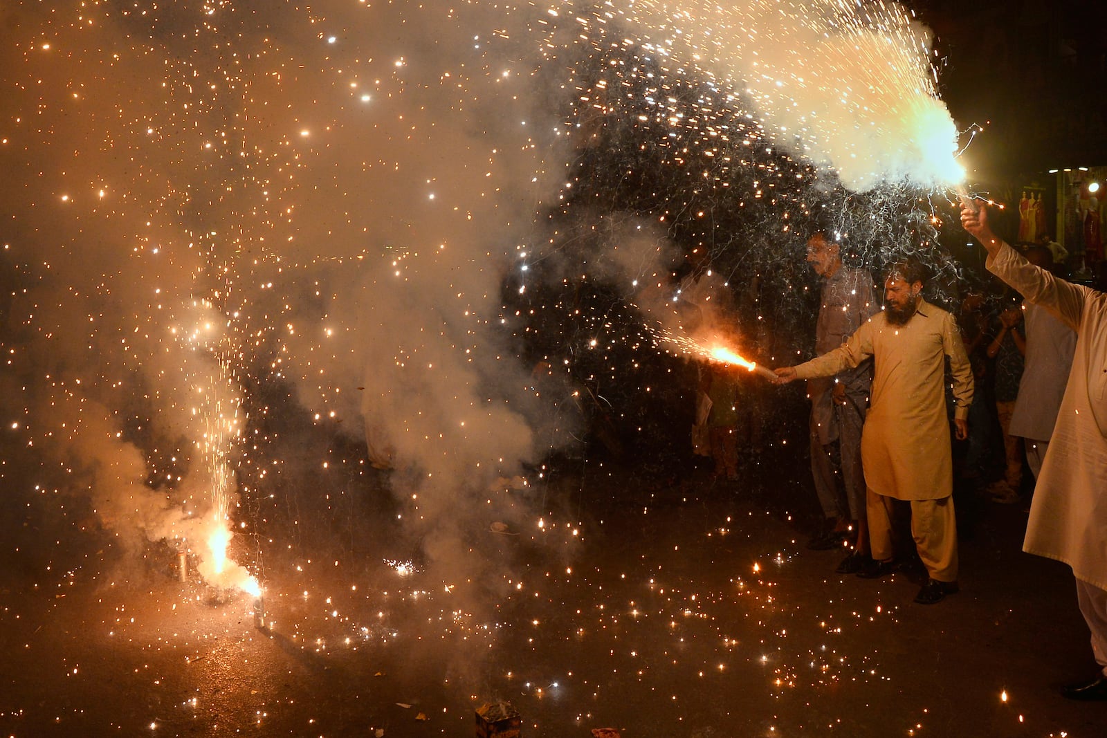 People light fireworks to celebrate Pakistan and India reaching a ceasefire deal, during a demonstration in Hyderabad, Pakistan, Saturday, May 10, 2025. (AP Photo/Pervez Masih)
