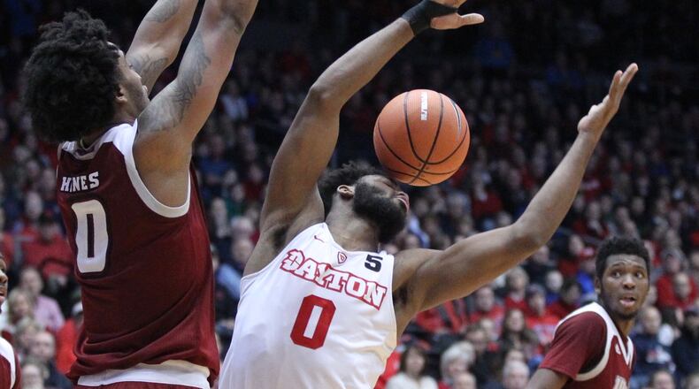 Dayton’s Josh Cunningham loses the ball as he’s guarded by Massachusetts’ Malik Hines on Saturday, Jan. 6, 2018, at UD Arena. David Jablonski/Staff