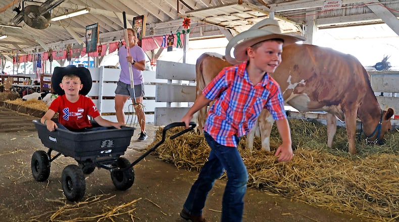 Jackson Cooke, left, and his cousin, Bodie, take turns pulling earch other around one of the cattle barns Monday, July 24, 2023 at the Clark County Fair. BILL LACKEY/STAFF