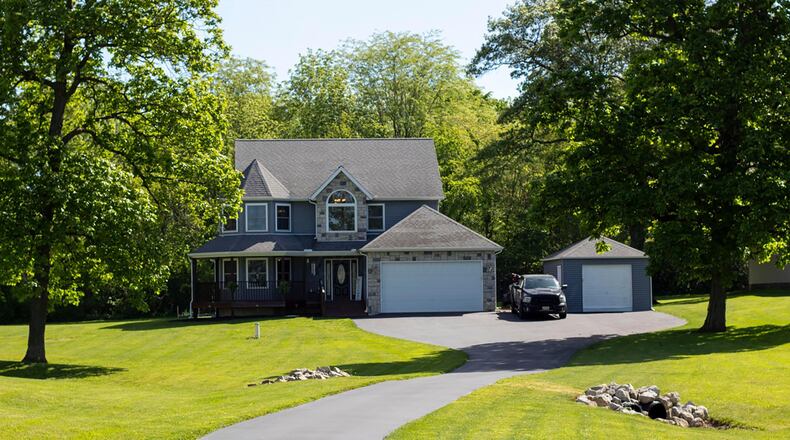 This stone and vinyl two story sits back on a wooded lot. It has a two car attached and one car detached garage and wrap around porch.