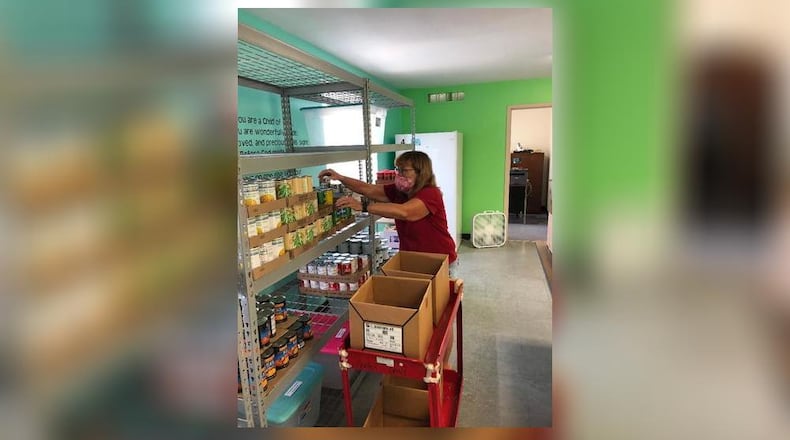 Donna Myers arranges food items for the Open Hands Food Pantry, located inside Covenant United Methodist Church, which was moved from Southern Village Shopping Center, for its grand opening on June 8. Contributed photo by Brett Turner