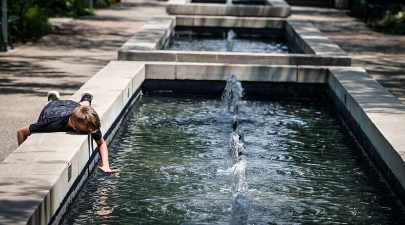 Thomas Phillips, from Dayton, enjoys the fountains at RiverScape MetroPark on Monument Ave. in downtown Dayton Wednesday July 5, 2023. JIM NOELKER/STAFF