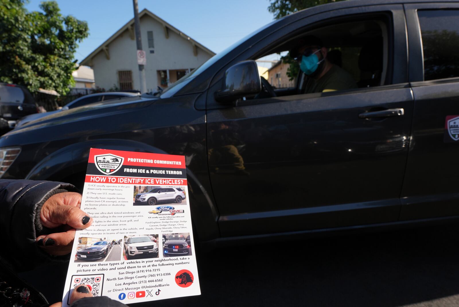 A member of the Union del Barrio, a grassroots political organization, distributes a "How to Identify ICE vehicles" flyer to people living in Los Angeles, Monday, June 16, 2025. (AP Photo/Damian Dovarganes)