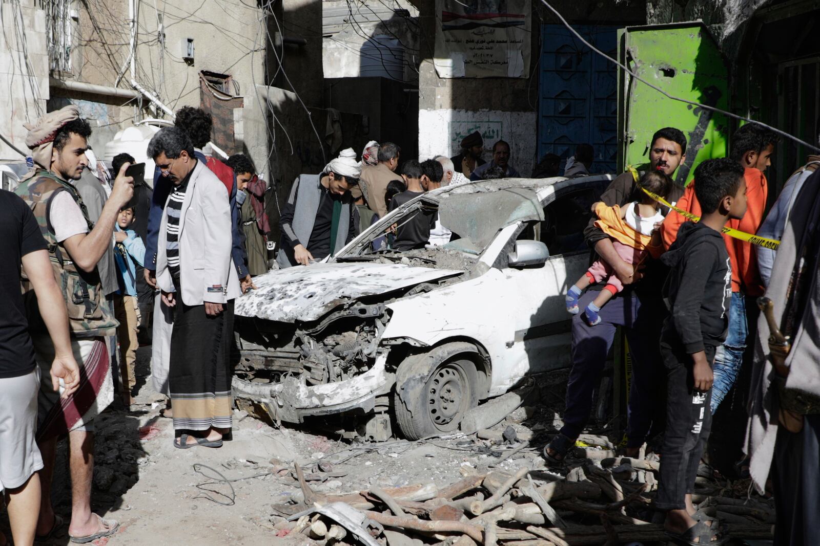 Yemenis watch a damaged vehicle at Farwah popular market, which Houthis said was struck by U.S. airstrikes, in Sanaa, Yemen, Monday, April 21, 2025. (AP Photo)
