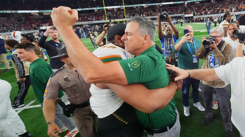 Miami head coach Mario Cristobal, right, hugs defensive lineman Ahmad Moten Sr. following the Cotton Bowl College Football Playoff quarterfinal game against Ohio State Wednesday, Dec. 31, 2025, in Arlington, Texas. (AP Photo/Julio Cortez)
