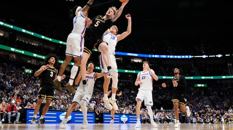 Vanderbilt forward Tyler Nickel (5) shoots the ball past Florida guard Boogie Fland (0) and forward Thomas Haugh (10) during the first half of an NCAA college basketball game in the semifinals of the Southeastern Conference tournament Saturday, March 14, 2026, in Nashville, Tenn. (AP Photo/George Walker IV)