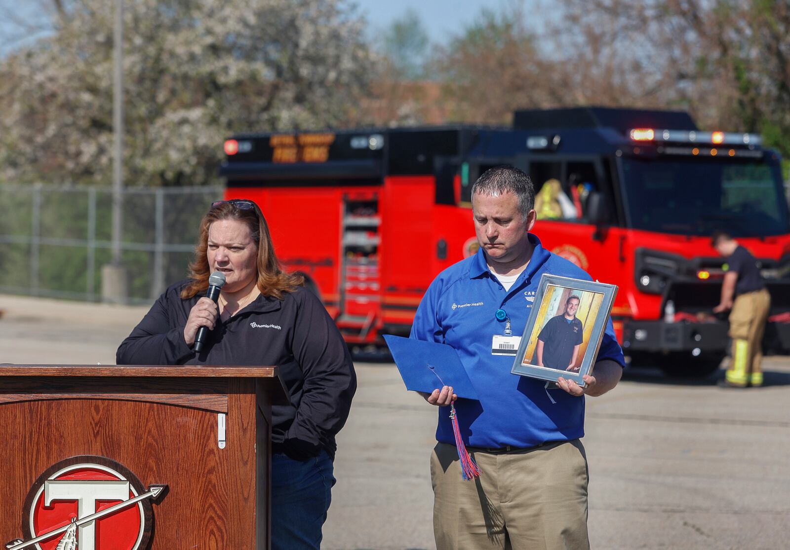 Laura Seger, left, of Pleasant Hill, talks about her son, Joey, who was killed at 18 by a driver under the influence to warn teenagers about the dangers of impaired driving next to Michael Moyer, left, flight nurse of Careflight Air & Mobile, during a mock crash simulation on Wednesday, April 23, 2025, at Tecumseh High School. JOSEPH COOKE/STAFF


