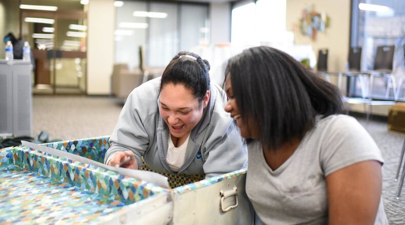 Odysyee Wilkerson and daughter Xhacaju work on decorating a trunk as part of Project Jericho’s National Poetry Month activities, which also included creating original poetry and working with established poets and artists. Courtesy photo