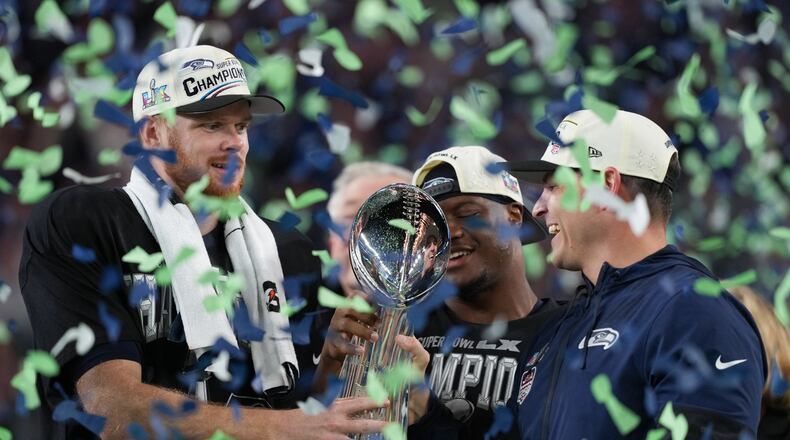 Seattle Seahawks head coach Mike Macdonald and quarterback Sam Darnold, left, hold the Lombardi Trophy after a win over the New England Patriots in the NFL Super Bowl 60 football game Sunday, Feb. 8, 2026, in Santa Clara, Calif. (AP Photo/Matt Slocum)