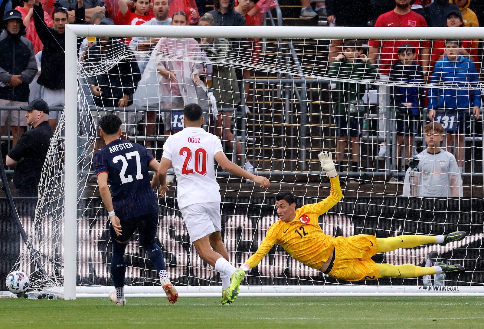 Turkey goalie Berke Özer (12) dives for but can't make the save on a goal by United States midfielder Jack McGlynn as United States defender Max Arfsten (27) and Turkey forward Oguz Aydin (20) look on during the first half of an international friendly soccer game, Saturday, June 7, 2025, in East Hartford, Conn. (AP Photo/Mary Schwalm)