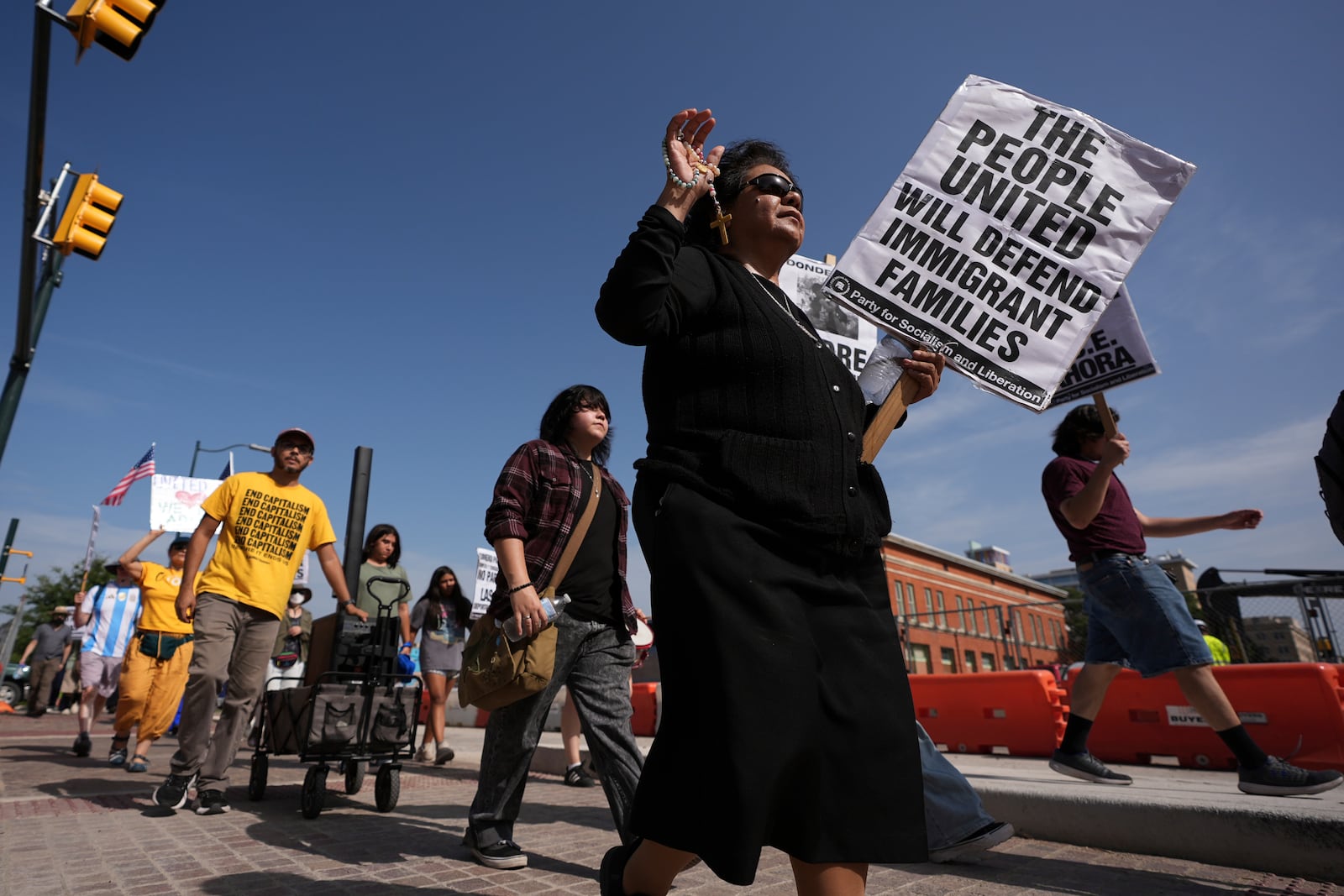 Sister RoseAnn Castilleja, center, holds a Rosary and sign as she marches with other immigration advocates as they protest recent detentions by ICE outside the immigration court in San Antonio, Texas, Tuesday, July 1, 2025. (AP Photo/Eric Gay)