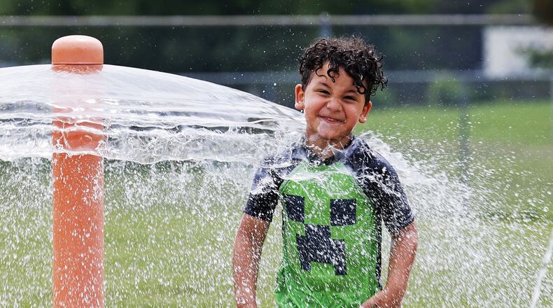 Ian Bailey, 4, cools off in the water at the spray ground at Booker T. Washington Community Center Monday, June 13, 2022 in Hamilton. NICK GRAHAM/STAFF