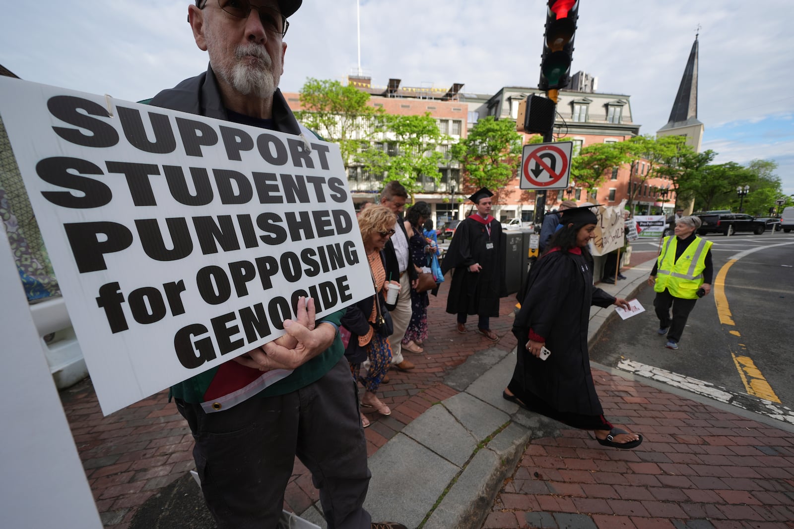 Students cross into Harvard yard passing protesters as Harvard University holds its commencement, Thursday, May 29, 2025 in Cambridge, Mass. (AP Photo/Charles Krupa)