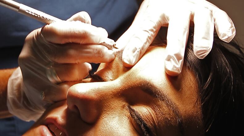 Peggy Allen demonstrates on Tasha Compton how you can apply permanent makeup using microblading at her studio. Bill Lackey/Staff