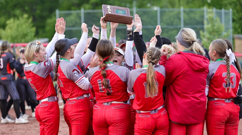 The Southeastern High School softball team hoists a district final trophy after beating Bradford 7-5 on Thursday night at Houston High School. MICHAEL COOPER / STAFF
