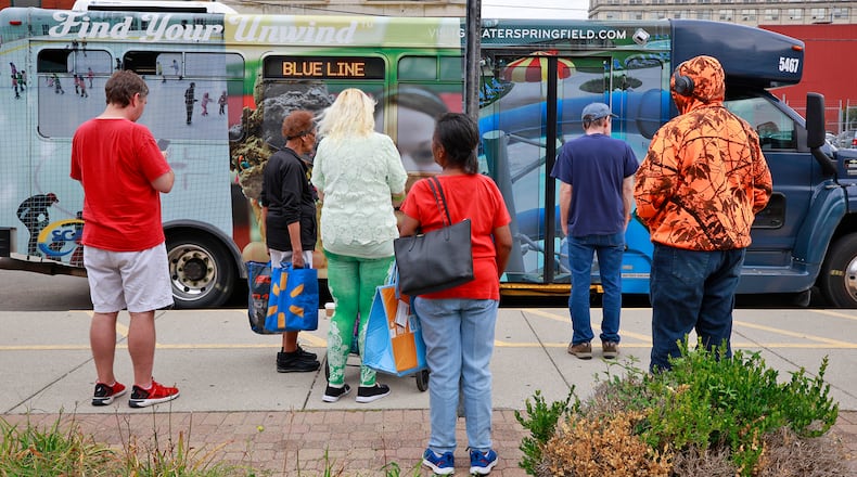 A group of people wait for their SCAT bus to arrive at the transit hub in downtown Springfield Thursday, August 15, 2024. BILL LACKEY/STAFF