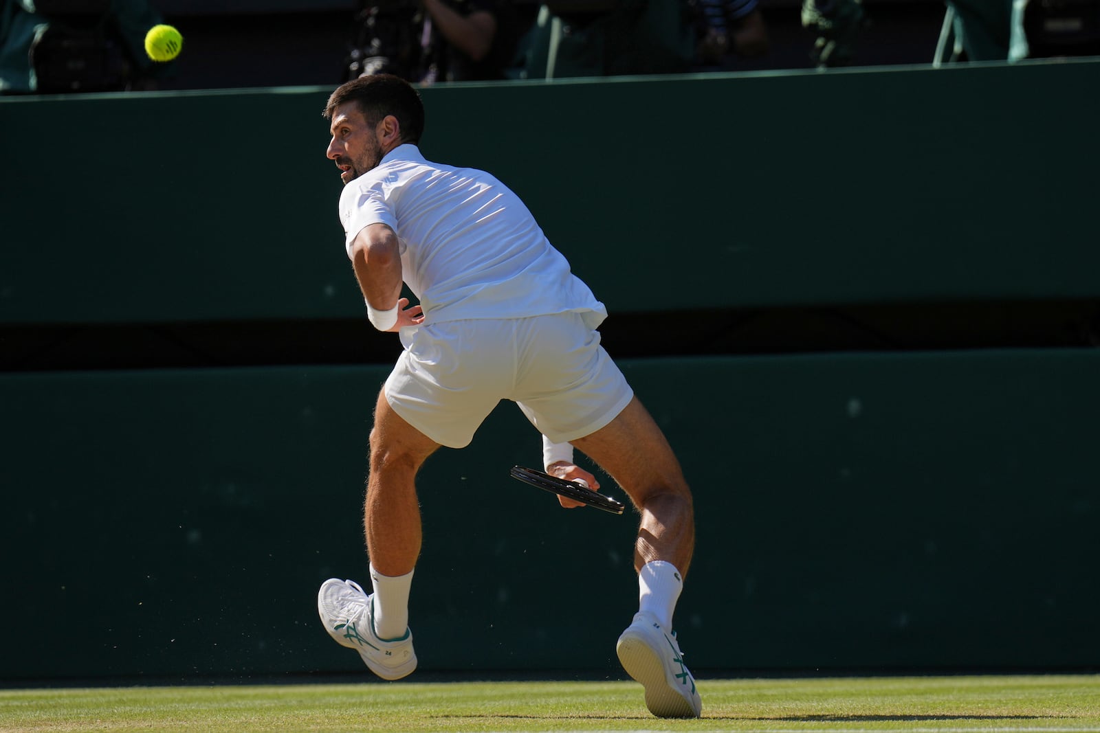Serbia's Novak Djokovic returns to Italy's Jannik Sinner in a men's singles semifinal at the Wimbledon Tennis Championships in London, Friday, July 11, 2025. (AP Photo/Kin Cheung)
