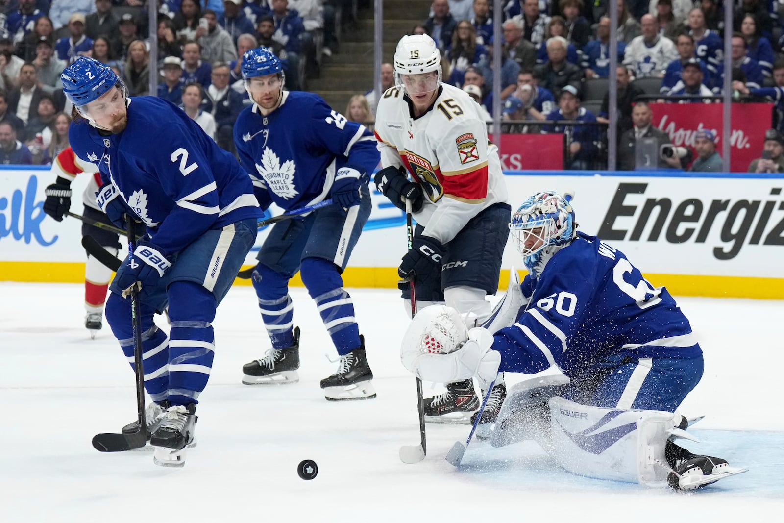 Toronto Maple Leafs goaltender Joseph Woll (60) makes a save while under pressure from Florida Panthers forward Anton Lundell (15) as Maple Leafs' Simon Benoit (2) and Brandon Carlo (25) watch during the third period of Game 1 in an NHL hockey second-round playoff series in Toronto, Monday, May 5, 2025. (Nathan Denette/The Canadian Press via AP)