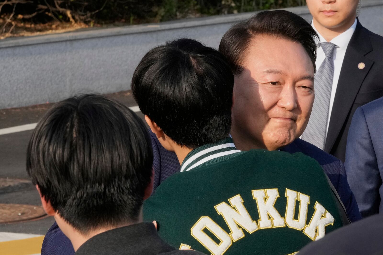 Recently ousted South Korean President Yoon Suk Yeol is greeted by a college student before he leaves the presidential residence in Seoul, South Korea, Friday, April 11, 2025. (AP Photo/Ahn Young-joon, Pool)
