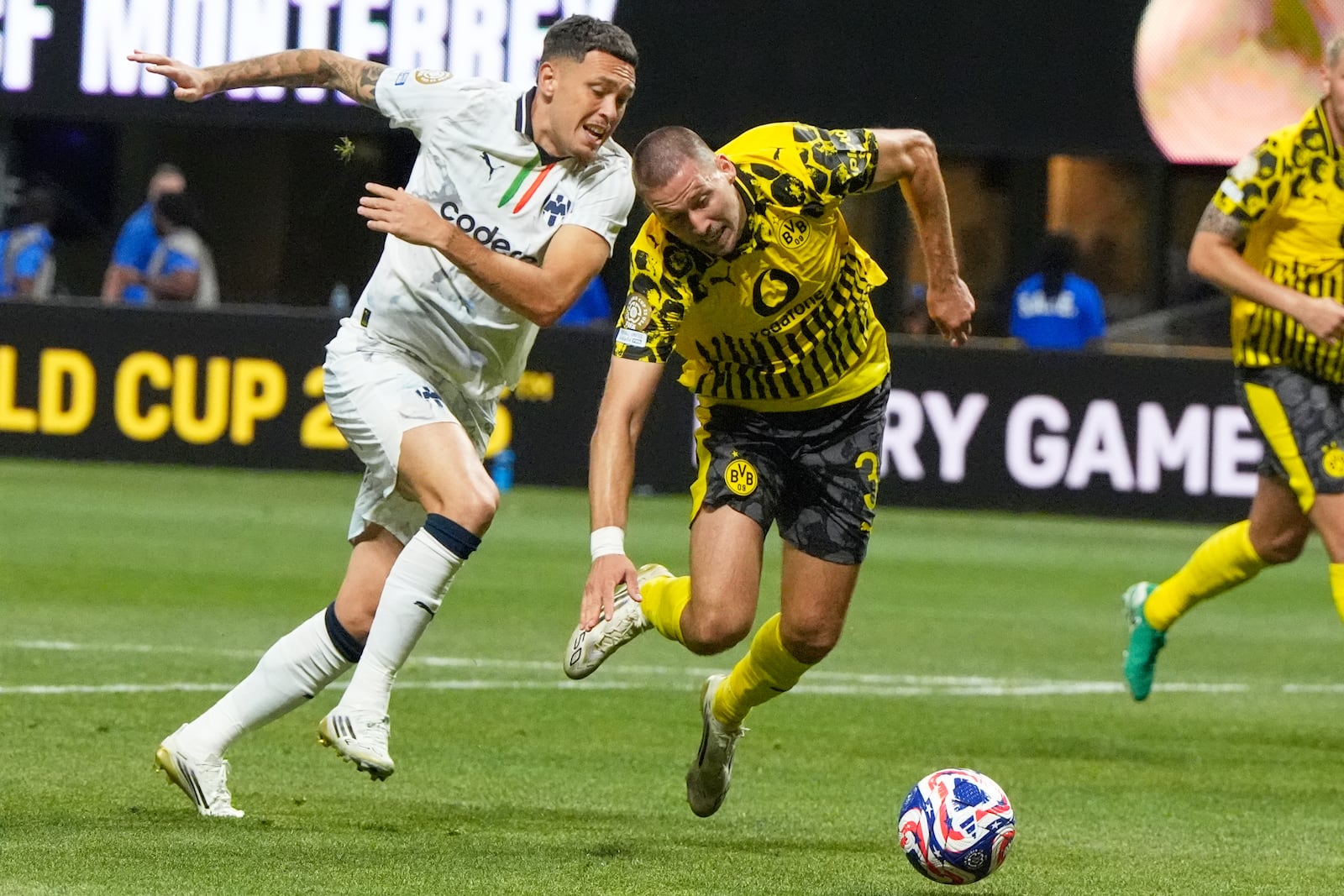 Monterrey's Lucas Ocampos, left, and Borussia Dortmund's Waldemar Anton compete for the ball during the Club World Cup round of 16 soccer match between Borussia Dortmund and CF Monterrey in Atlanta, Tuesday, July 1, 2025. (AP Photo/Mike Stewart)