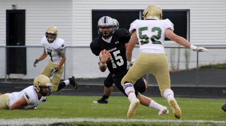 Graham High School quarterback Gage Braun runs through the Catholic Central High School defense during the Falcons 54-20 victory over the Irish in St. Paris. MICHAEL COOPER/STAFF