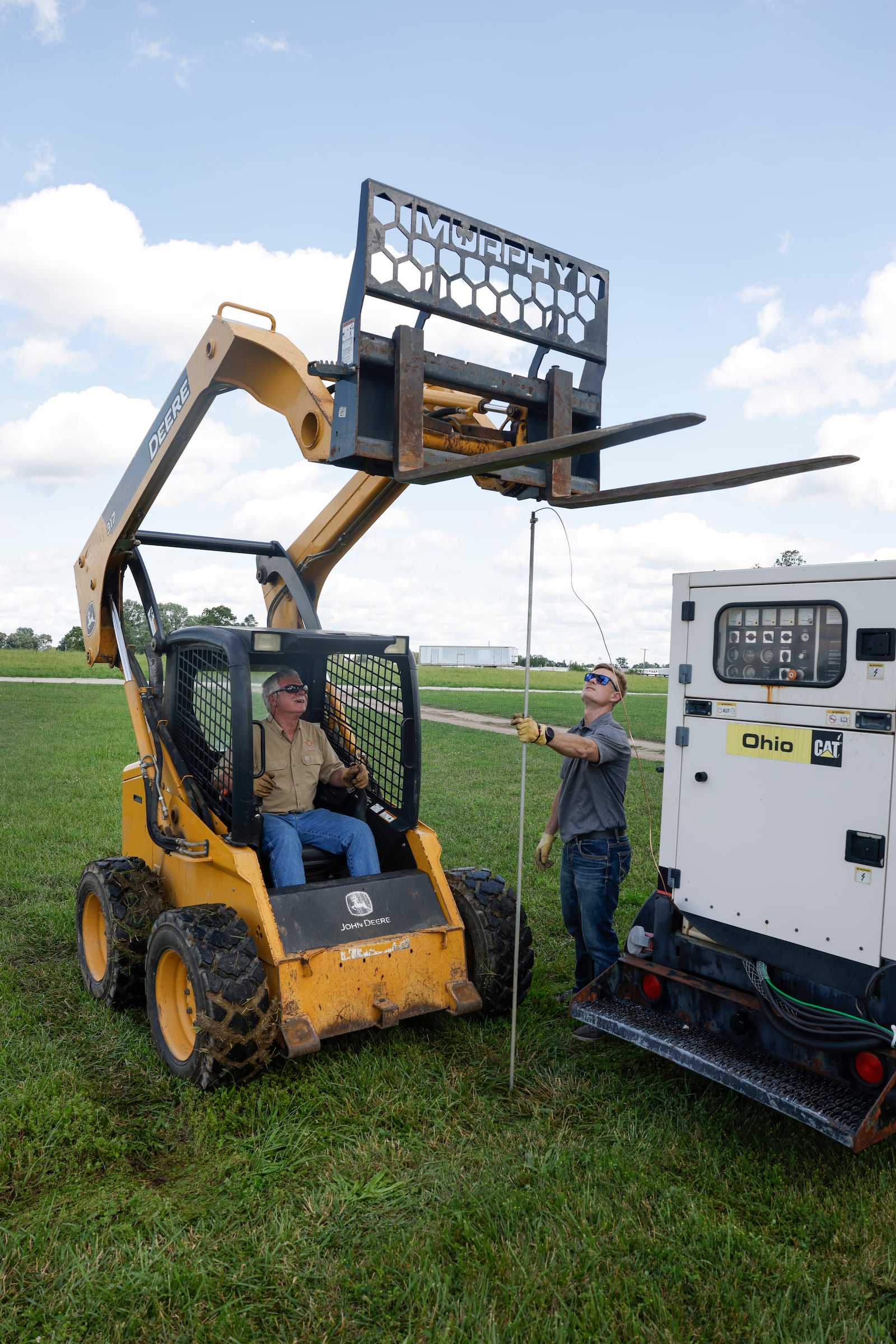Bob Holder, left, and his son, Travis Holder, strategize on where to place a grounding rod for electric service on Thursday, June 19, 2025, to prepare for an upcoming event at the Evans Family Ranch in New Carlisle. JOSEPH COOKE/STAFF