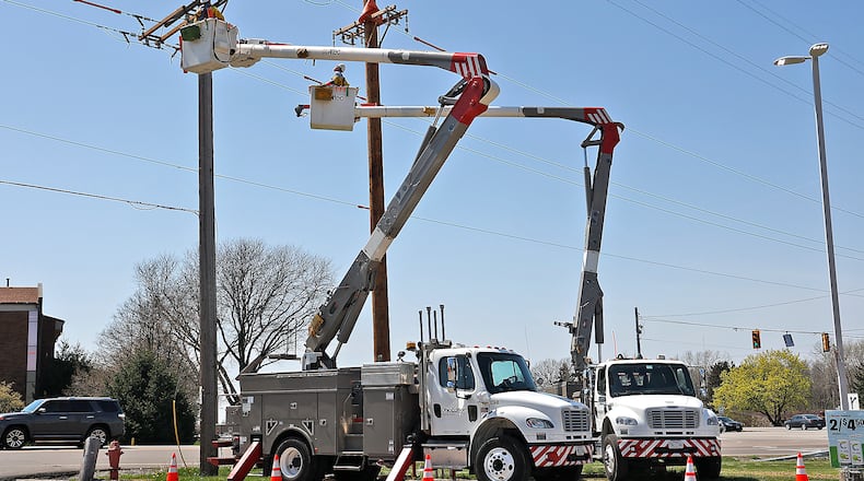 An Ohio Edison crew works on the power lines at the intersection of Urbana Road and Moorefield Road Wednesday, April 19, 2023. BILL LACKEY/STAFF