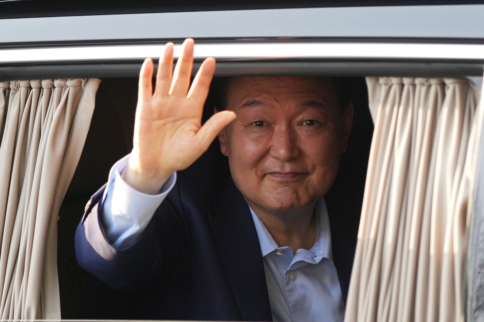 Former South Korean President Yoon Suk Yeol waves upon his arrival at the private residence in Seoul, South Korea, Friday, April 11, 2025. (AP Photo/Lee Jin-man)