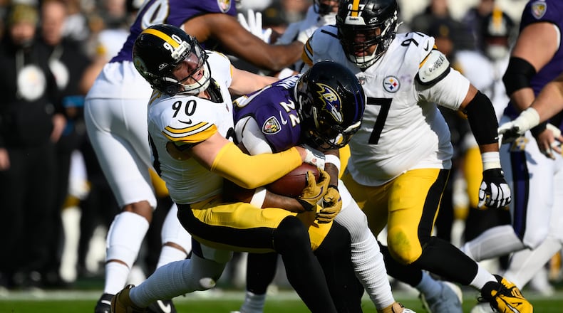 Pittsburgh Steelers linebacker T.J. Watt (90) tackles Baltimore Ravens running back Derrick Henry (22) during the first half of an NFL football game, Sunday, Dec. 7, 2025, in Baltimore. (AP Photo/Nick Wass)