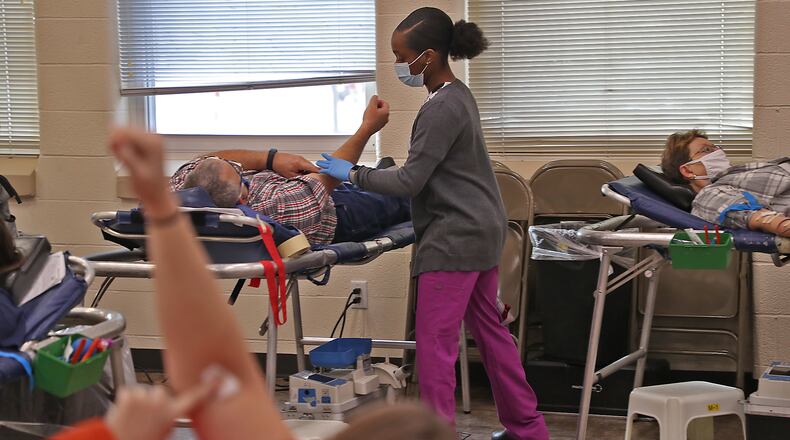 People donate blood during a blood drive Monday at the Father Paul Vieson Center in New Carlisle. BILL LACKEY/STAFF