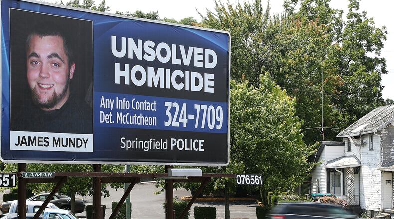 Cars drive past a billboard along East Main Street, placed by the Springfield Police Division, asking for help solving an unsolved homicide case. BILL LACKEY/STAFF