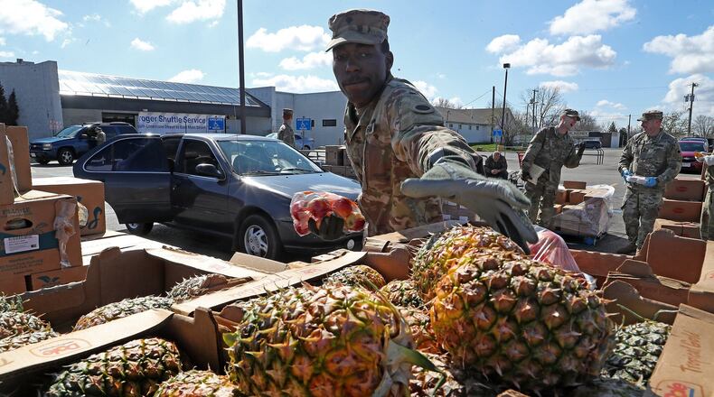 National Guardsmen, based in Springfield, distributed food for the Second Harvest Food Bank at the old Kroger parking lot on South Limestone Thursday. BILL LACKEY/STAFF