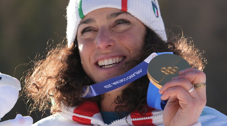 Italy's Federica Brignone shows her gold medal in an alpine ski, women's giant slalom race, at the 2026 Winter Olympics, in Cortina d'Ampezzo, Italy, Sunday, Feb. 15, 2026. (AP Photo/Jacquelyn Martin)