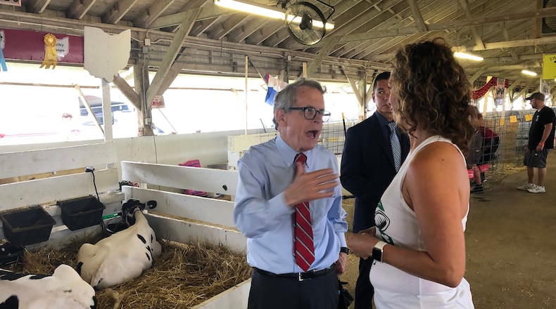 Governor Mike DeWine talks with Clark County Commissioner Melanie Flax-Wilt Monday at the Clark County Fair. DeWine stopped by to see his granddaughter, who was showing her goat at the Fair. BILL LACKEY/STAFF