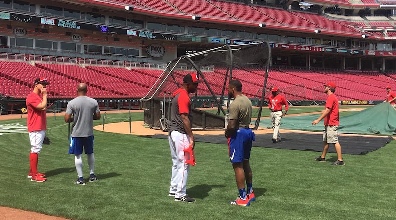 Reds first base coach Delino DeShields, left center, and Delino DeShields Jr., of the Rangers, talk before a game on Friday, June 14, 2019, at Great American Ball Park in Cincinnati. David Jablonski/Staff