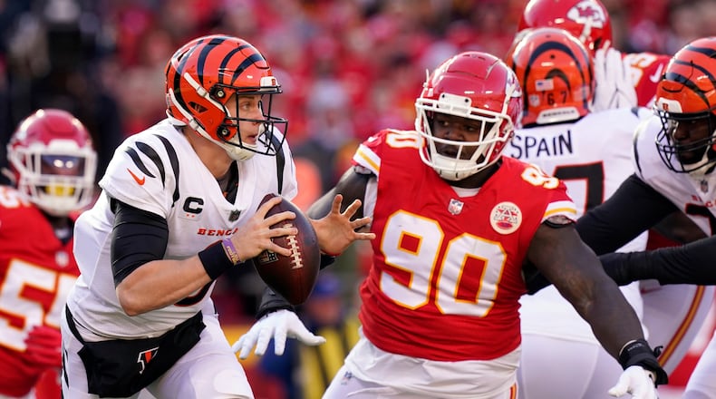 Cincinnati Bengals quarterback Joe Burrow (9) scrambles out of the pocket under pressure from Kansas City Chiefs defensive tackle Jarran Reed (90) during the first half of the AFC championship NFL football game, Sunday, Jan. 30, 2022, in Kansas City, Mo. (AP Photo/Eric Gay)