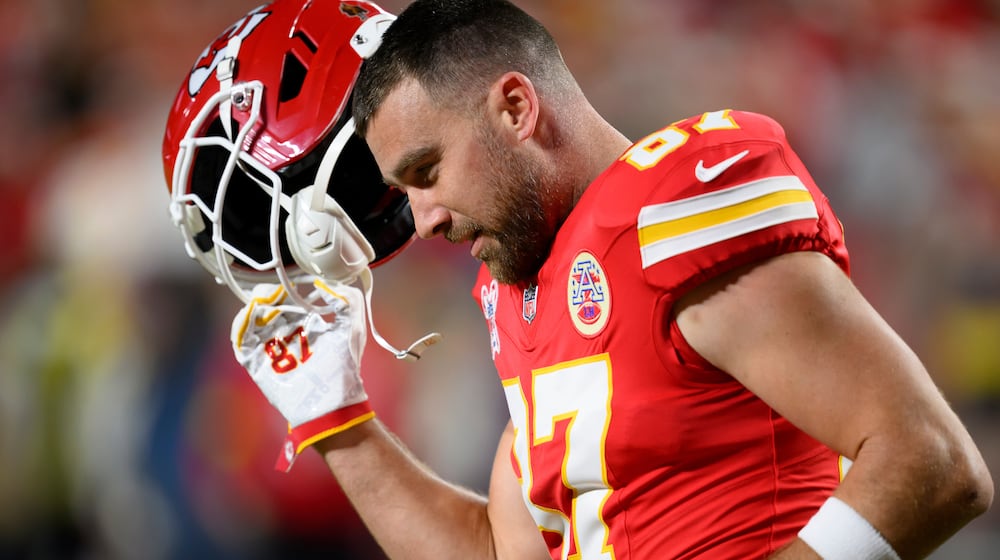 FILE - Kansas City Chiefs tight end Travis Kelce takes off his helmet during warmups before an NFL football game against the Denver Broncos, Dec. 25, 2025, in Kansas City, Mo. (AP Photo/Reed Hoffmann, File)