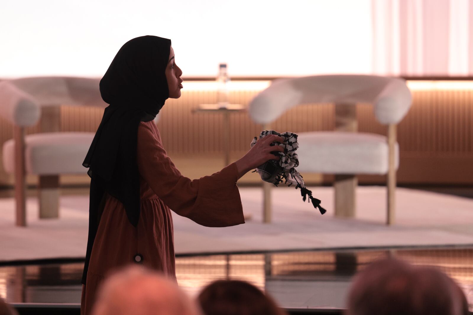 A pro-Palestinian demonstrator holds a kufiyyeh as they interrupt Microsoft AI CEO Mustafa Suleyman during a presentation of the company's AI assistant, Copilot, ahead of a 50th Anniversary presentation at Microsoft headquarters, Thursday, March 14, 2024, in Redmond, Wash. (AP Photo/Jason Redmond)