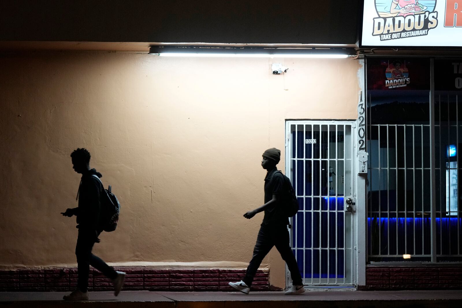 FILE - High school students walk in the dark to school, Oct. 29, 2024, in North Miami, Fla. (AP Photo/Marta Lavandier, File)