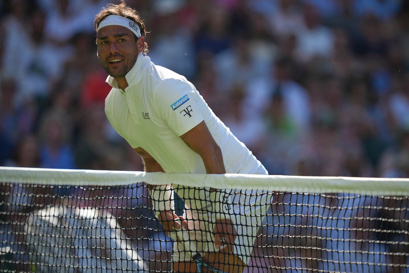 Fabio Fognini of Italy walks into the net and loses the point as he plays Carlos Alcaraz of Spain during their first round men's singles match at the Wimbledon Tennis Championships in London, Monday, June 30, 2025. (AP Photo/Alastair Grant)
