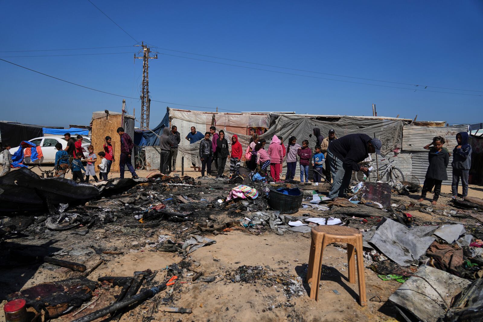 Palestinians inspect the remains of a displacement tent hit by an Israeli airstrike overnight, killing 10 members of the Abu Al-Rous family, in Khan Younis, southern Gaza Strip, Thursday, April 17, 2025. (AP Photo/Abdel Kareem Hana)
