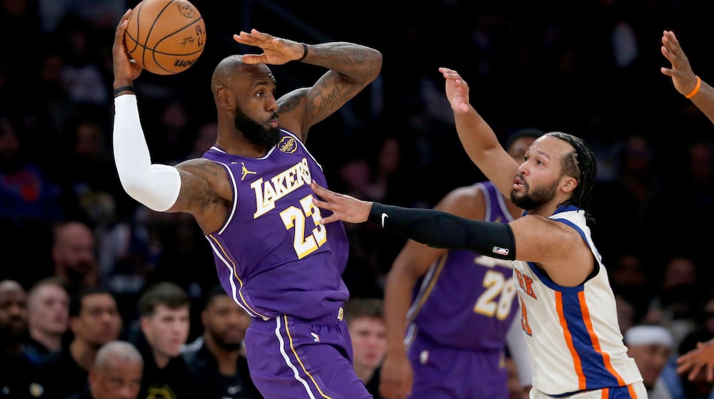 Los Angeles Lakers forward LeBron James, left, looks to pass the ball around New York Knicks guard Jalen Brunson, front right, during the first half of an NBA basketball game, Sunday, Feb. 1, 2026, in New York. (AP Photo/John Munson)