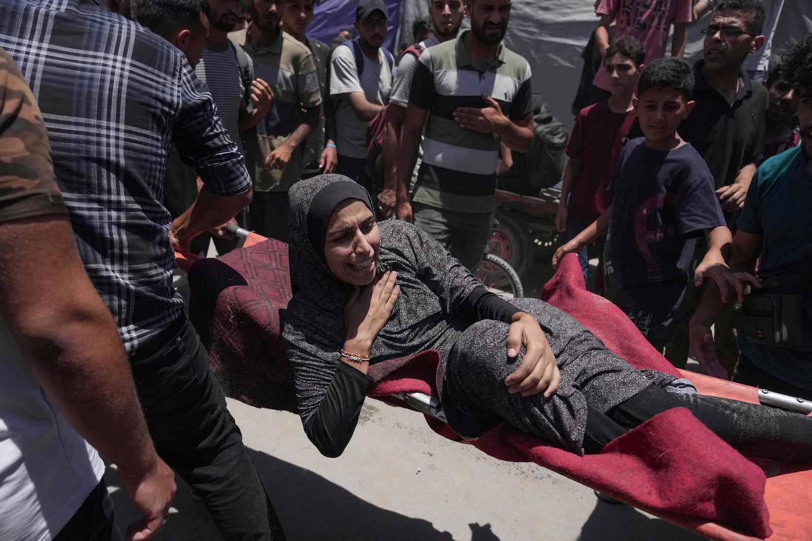 A woman is evacuated after an Israeli strike on tents sheltering displaced Palestinians in Gaza City on Tuesday, July 8, 2025. (AP Photo/Jehad Alshrafi)