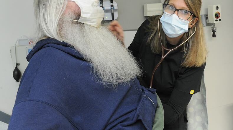 Dr. Eve Connolly, medical director for the Wright-Patterson VA clinic examines Charles S. Rice, retired Air Force master sergeant at the VA clinic at the Wright-Patterson Medical Center . MARSHALL GORBY\STAFF