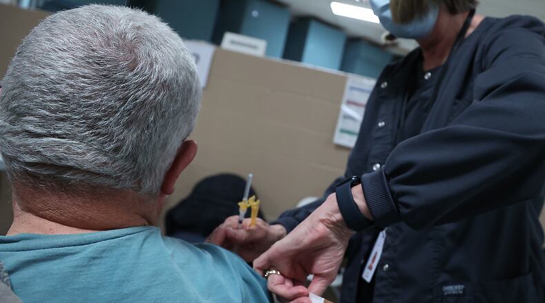 A patient gets his COVID booster shot at the Clark County Combined Health District's Vaccine Center in January. BILL LACKEY/STAFF
