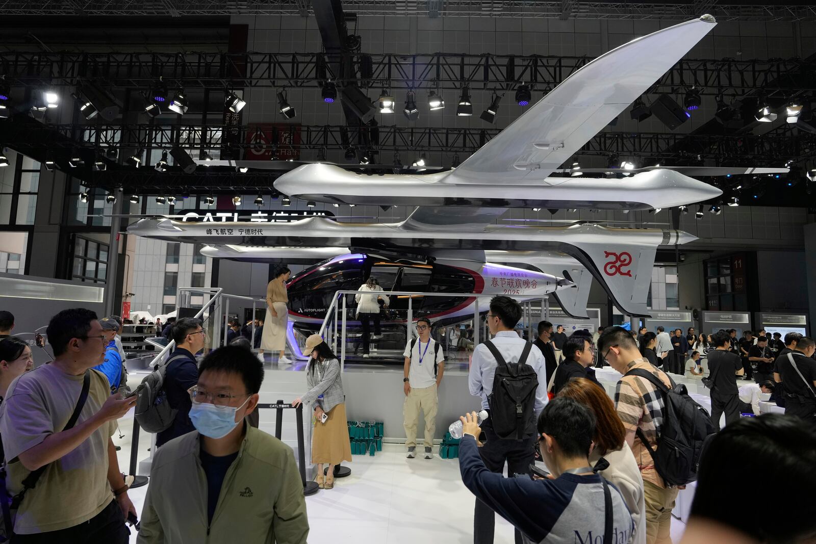 Visitors stand near a flying test platform from Chinese battery manufacturer CATL during the Shanghai auto show on Wednesday, April 23, 2025. (AP Photo/Ng Han Guan)