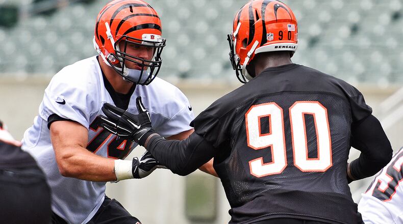 Bengals’ offensive tackle Jake Fisher, left, blocks defensive end Michael Johnson during practice Wednesday, June 17 at Paul Brown Stadium in Cincinnati. NICK GRAHAM/STAFF