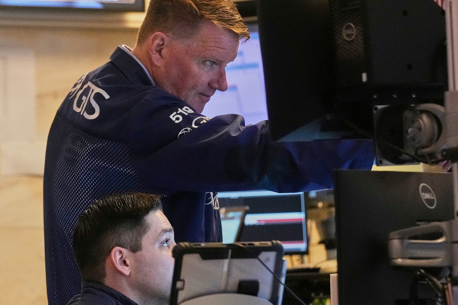 Trader John Bowers, top, works on the floor of the New York Stock Exchange, Friday, April 25, 2025. (AP Photo/Richard Drew)